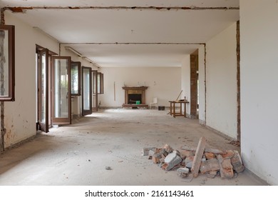 Large bright room with many windows of an old villa undergoing demolition and renovation. The walls have been knocked down and the floor is gone. Nobody inside - Shutterstock ID 2161143461