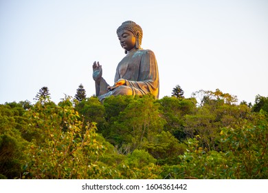 Large bronze statue of Tian Tan Buddha Shakyamuni in Lantau Island at the top of green mountain. Centre of Buddhism and major tourist attraction.