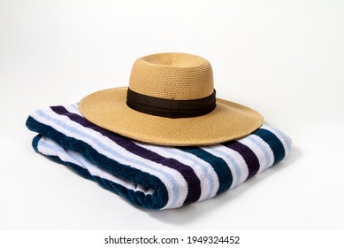 A Large Brown Brim On A Striped Beach Towel With A White Background