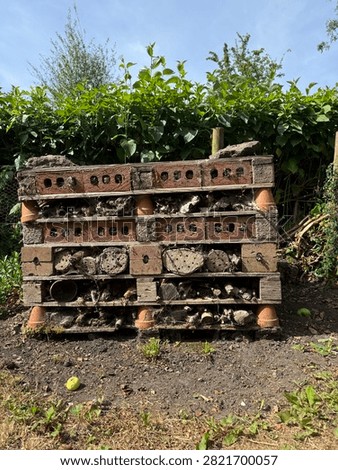 Large bug hotel made from brick wood and clay in an English garden 