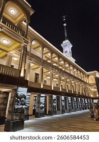 Large building with a clock tower and a statue on top. The building River soviet port is lit up at night in Moscow