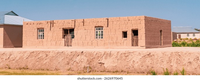 A large building with a lot of windows. The building is made of bricks. There are two people standing in front of the building