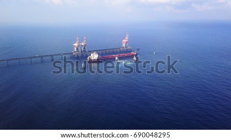 Large bulk carrier ship pulled / pushed by 3 tugboats in big power station dock - aerial shots