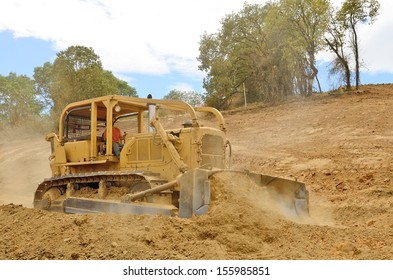 A Large Bulldozer Spreads Dirt And Rock For A New Fill Layer On A Commercial Construction Road Project