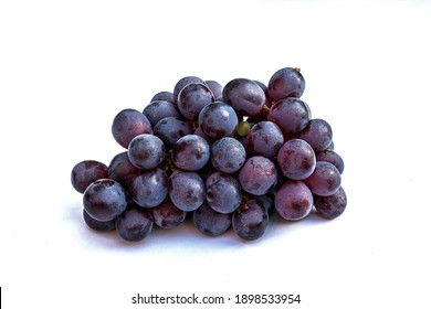 A large bunch of black grapes on a white background