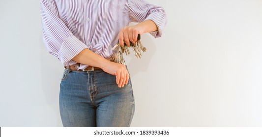 A large bunch of keys does not fit into a jeans pocket for a young woman