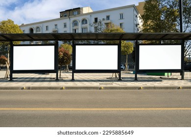 A large bus stop against the background of houses  with empty advertising banners inside. Template for design.