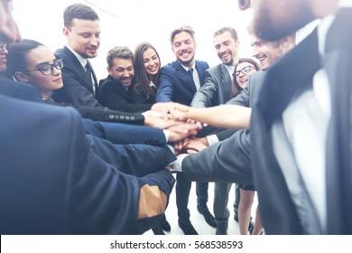Large business team showing unity with their hands together - Shutterstock ID 568538593