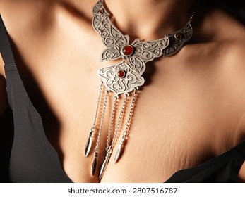 Large butterfly statement choker with dangling chains and beautiful red gemstones surrounded by swirling engravings