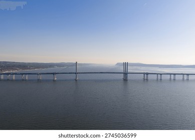 Large cable stayed bridge connecting two shores over a vast body of water, symbolizing infrastructure, progress, and engineering in a bright daytime setting