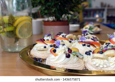 Large Cakes Anna Pavlova On The Background Of The Workspace, A Tree In A Pot And Lemon-mint Mojito