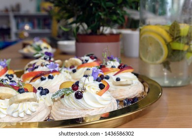 Large Cakes Anna Pavlova On The Background Of The Workspace, A Tree In A Pot And Lemon-mint Mojito