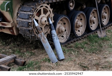 Large caliber tank shells at side of armored vehicle.