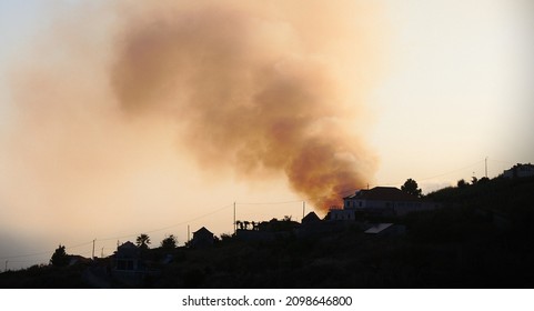 Large Campfire Behind A Building On A Hill In Madeira, Portugal