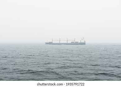 Large Cargo Container Crane Ship Sailing In An Open Sea. Fog, Storm, Rough Weather.  