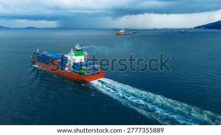 large cargo container ship leaving a white wake as it sails towards a dramatic dark storm and heavy rain over the ocean. Concept of navigating supply chain challenges, maritime resilience, and global trade logistics.