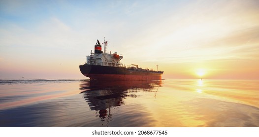 Large Cargo Ship Sailing In The Baltic Sea At Sunset. Soft Golden Sunlight. Concept Seascape. Panoramic View From The Sailing Boat. Freight Transportation, Nautical Vessel, Logistics