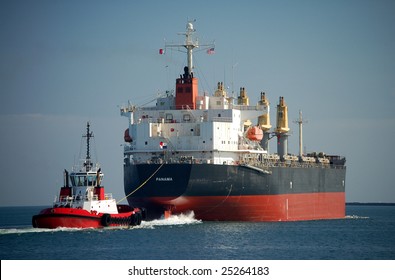 Large Cargo Ship And Tug Boat.