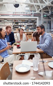 Large Casual Business Group Of Young Coworkers On A Lunch Break In The Office Restaurant