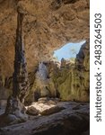 A large cave with rugged rock formations and a tall stalagmite.