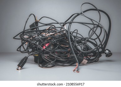 Large chaotic mixed cable, wire node on a gray background. Old, tangled wires from household appliances and gadgets. - Shutterstock ID 2108556917