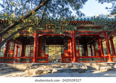 A large Chinese gazebo structure with open doors and windows, adorned with dense sculptures and ornaments surrounding a Chinese writing that translates "The Lake of Yizhenshan." - Powered by Shutterstock