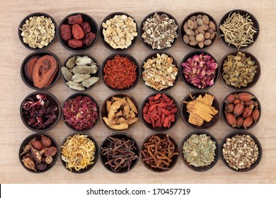 Large Chinese Herbal Medicine Selection In Wooden Bowls Over Papyrus Background.