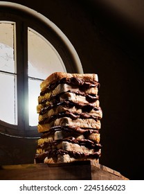 Large chocolate cream sandwich consisting of several pieces of toasted bread against a window. High quality creative photo