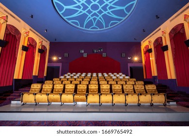 Large Cinema Theater Interior With Seat Rows For Audience To Sit In Movie Theater Premiere By Cinematograph Projector. The Cinema Theater Is Decorated In Classical For Luxury Feel Of Movie Watching.