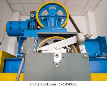The large circle wheel of the passenger elevator motor in the control room on the top of the building, selectively focused on the first circle wheel, front view with the copy space.