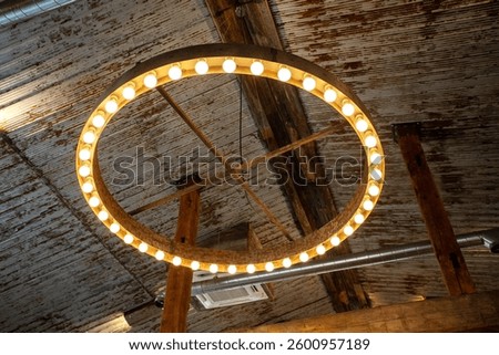 Large circular light fixture interior design decorating high ceilings. Metal, rustic, weathered, country, industrial. Exposed ducting duct work ducts  bulbs, ring, hanging. Contemporary. 