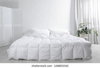 Large comfortable bed in light room. Stylish interior