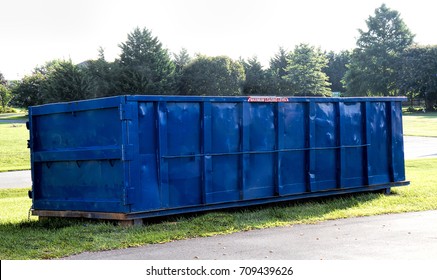 Large Commercial Dumpster Sitting In Yard Waiting To Be Filled With Old Siding From House As It Is Being Updated To New Vinyl Siding.