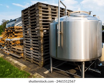 Large Commercial Stack Of Pallets With a Beer Brewery Stainless Steel Tank. - Powered by Shutterstock