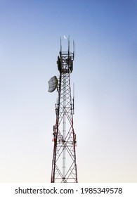 A Large Communications Tower In Rural Australia, With A Daytime Picture Of The Moon Located Between The Twin Aerials At The Top.