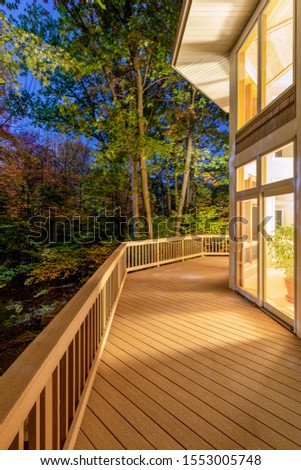 Large composite deck on a luxury home in the woods photographed at night.  Concepts could include architecture, design, outdoor living, luxury living, nature, others.