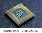 Large computer chip CPU with hundreds of gold pins and tiny components - capacitors, resistors on its board. Concept for microchips and semiconductor inducstry. Selective focus.