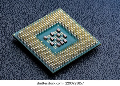 Large computer chip CPU with hundreds of gold pins and tiny components - capacitors, resistors on its board. Concept for microchips and semiconductor inducstry. Selective focus.