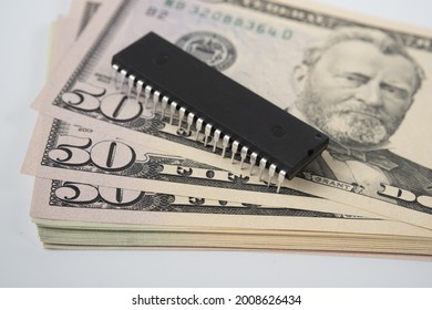 Large Computer Chip Placed On Top Of Stack Of 50 US Dollar Banknotes. Concept For Investment In Semiconductor Industry And Golbal Chip Shortage.