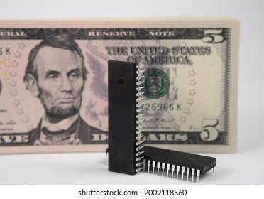 Large Computer Chips Placed Next To 5 US Dollar Banknotes. Concept For Investment In Semiconductor Industry And Golbal Chip Shortage.