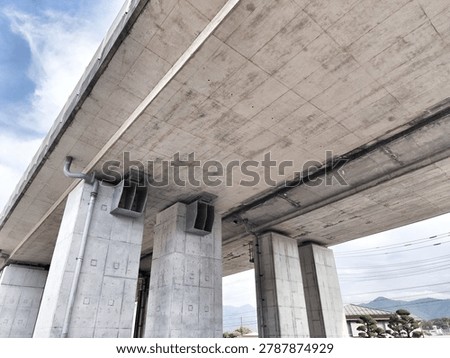 A large concrete bridge with vertical support columns and underbelly visible, showing construction details and clean lines for architectural or infrastructure themed use.