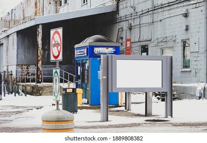 A large concrete building painted blue in the old port of Montreal. LCD display, road signs and parking booth, Canada. Translation: "Automated teller"
