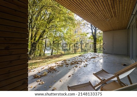 Large concrete terrace at home with a beautiful view of nature, trees. forest. Chairs for relaxing on a sunny morning. 