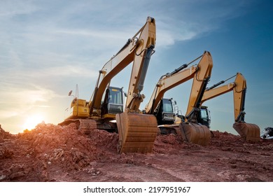 A large construction excavator of yellow color on construction site in quarry for quarrying. Industrial image. Excavator with Bucket lift up digging the soil in the construction site on sky background
