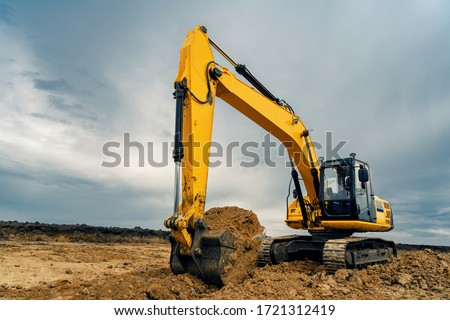 A large construction excavator of yellow color on the construction site in a quarry for quarrying. Industrial image.