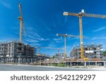 Large construction site with several cranes, foundations and buildings