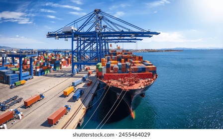 A large container cargo ship is beeing loaded and unloaded in a commercial dock - Powered by Shutterstock