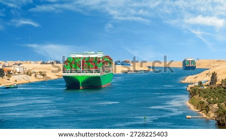 Large container ship, accompanied by tugboat, passing through the Suez Canal in Egypt.