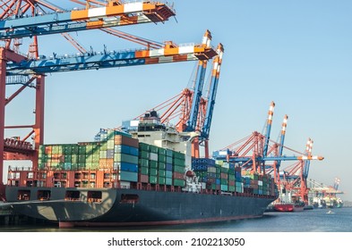 Large container vessel and harbour facilities at a container terminal in the port area of Hamburg, Germany  - Shutterstock ID 2102213050