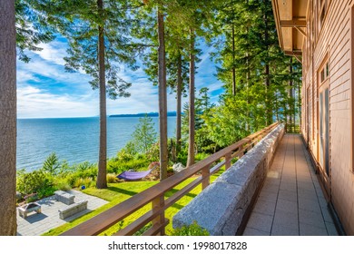 Large contemporary waterfront estate with natural woods blue sky and lush green grass in pacific northwest - Powered by Shutterstock